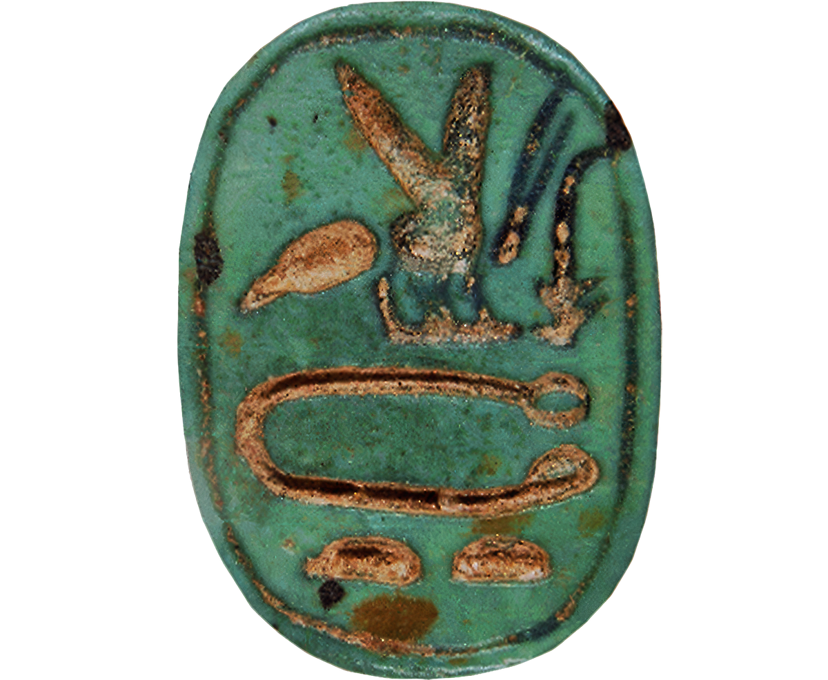 An ancient Egyptian green glazed seal with brown and gold painted symbols